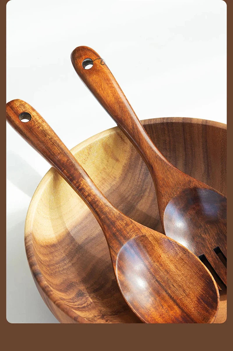 Wooden large spoon and fork set with long handles in a Japanese style, displayed in a wooden bowl.