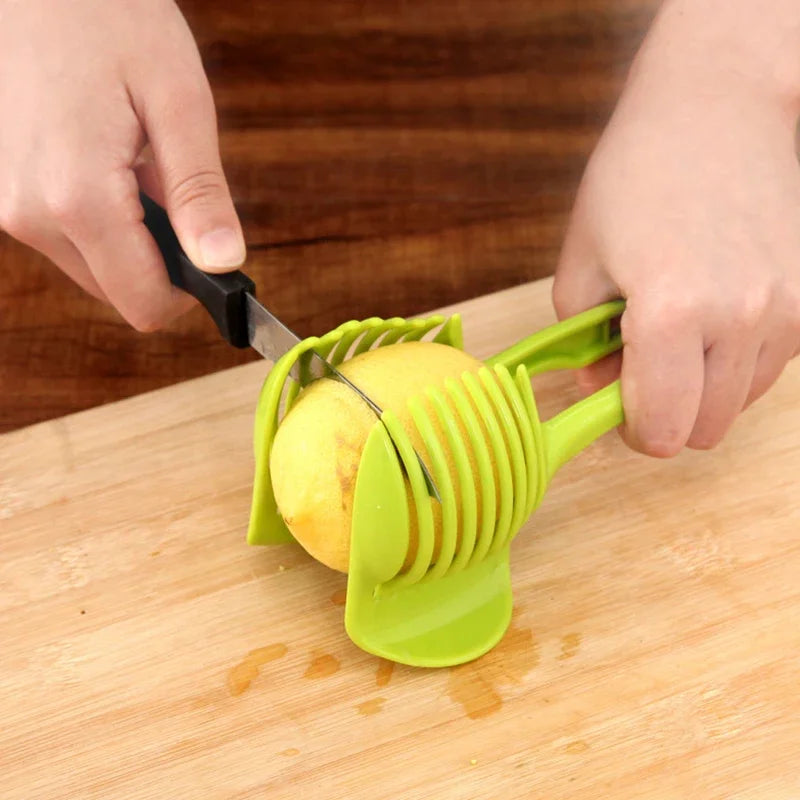 Stainless steel handheld fruit slicer cutting lemon on a wooden board.